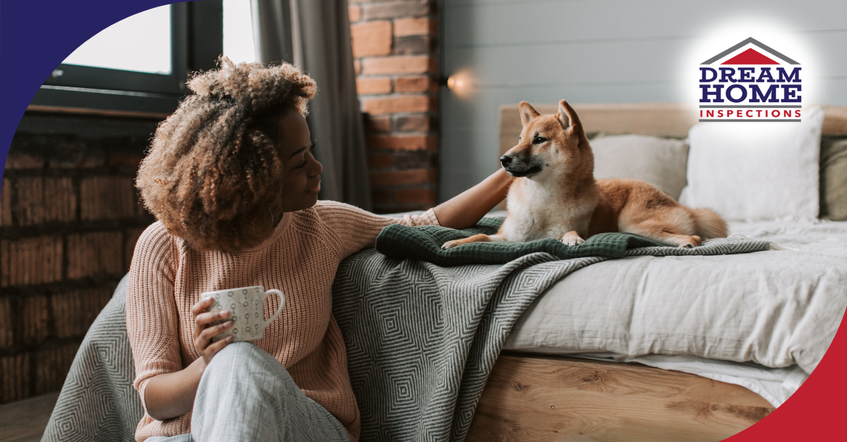 Woman enjoying coffee while petting her dog on the bed.