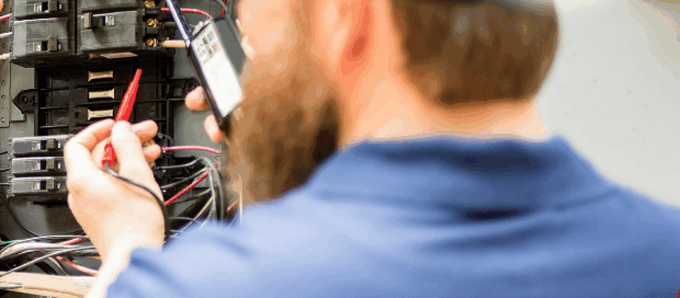 Two home inspectors evaluating an electrical panel during a property inspection