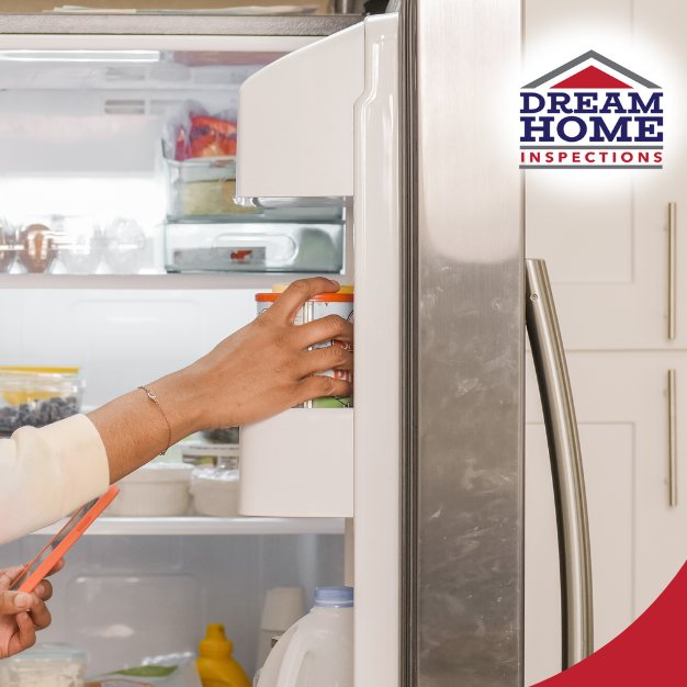 Smiling woman placing food into a refrigerator in a modern kitchen.