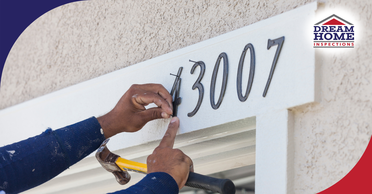Person installing house number 43007 on an exterior wall