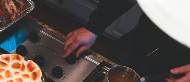 Close-up of a Thanksgiving meal with turkey, marshmallow-topped sweet potatoes, and a festive autumn setting on the kitchen counter.