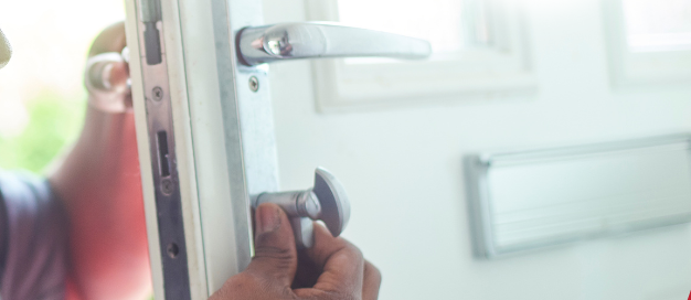 Technician installing or adjusting a front door lock.