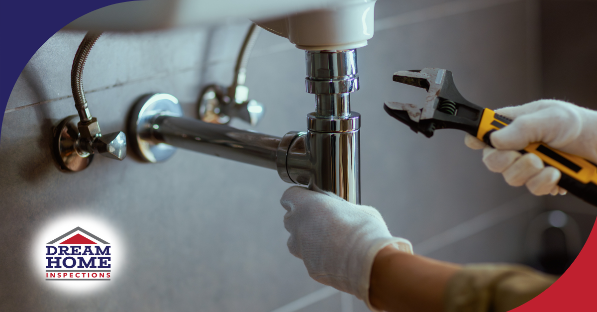 Inspector adjusting plumbing connections under sink.